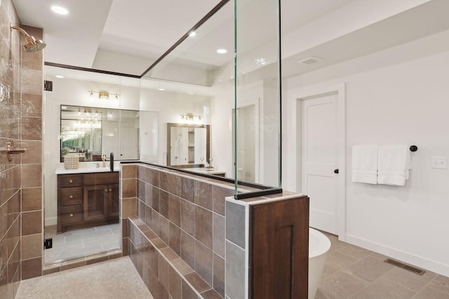 bathroom featuring a shower with door and vanity