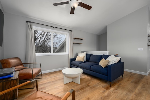 living area with baseboards, lofted ceiling, ceiling fan, and wood finished floors