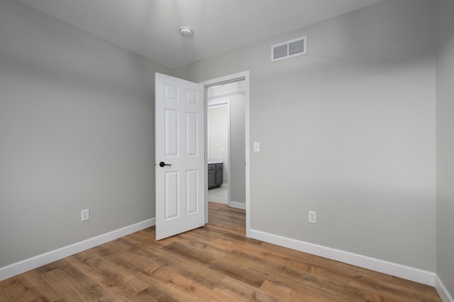 empty room with visible vents, baseboards, and wood finished floors