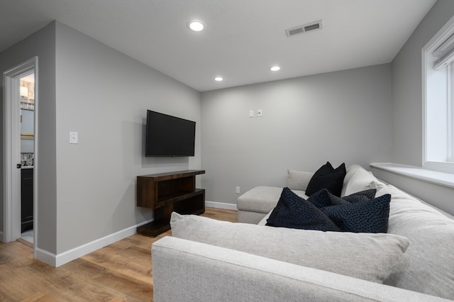 living area with recessed lighting, visible vents, baseboards, and light wood finished floors