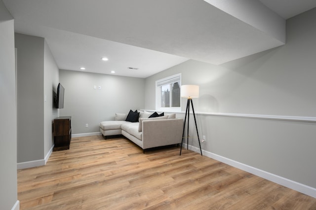 living area featuring recessed lighting, baseboards, and light wood-style flooring