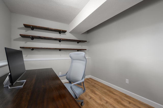 office space with wood finished floors, baseboards, and a textured ceiling