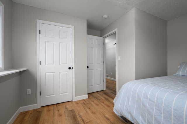 bedroom featuring light wood-style flooring and baseboards