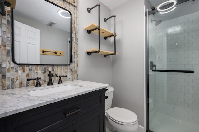 full bathroom featuring decorative backsplash, toilet, visible vents, and a stall shower