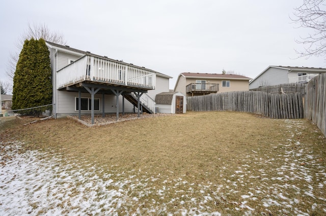 back of house featuring an outbuilding, a wooden deck, a fenced backyard, stairs, and a storage shed