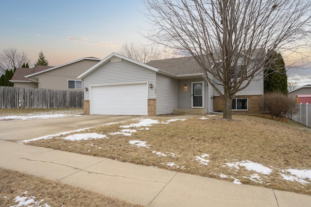 ranch-style house with brick siding, driveway, a garage, and fence