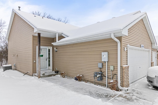 view of front of property with a garage and central air condition unit