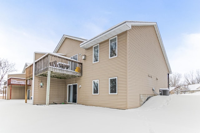 snow covered property featuring a wooden deck and central air condition unit