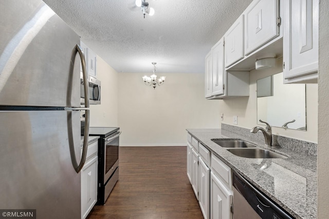 kitchen featuring sink, hanging light fixtures, stainless steel appliances, dark hardwood / wood-style floors, and white cabinets