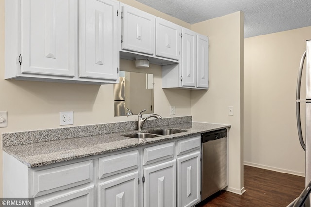 kitchen featuring sink, white cabinetry, a textured ceiling, stainless steel appliances, and light stone countertops