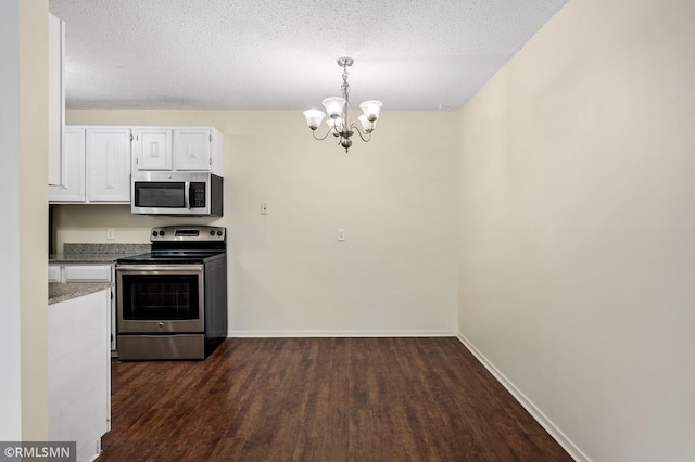 kitchen with decorative light fixtures, white cabinets, dark hardwood / wood-style flooring, stainless steel appliances, and a textured ceiling