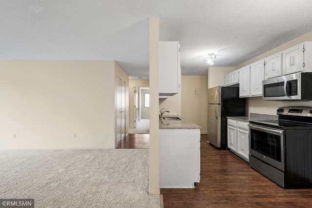 kitchen featuring sink, white cabinetry, stainless steel appliances, dark hardwood / wood-style floors, and a textured ceiling