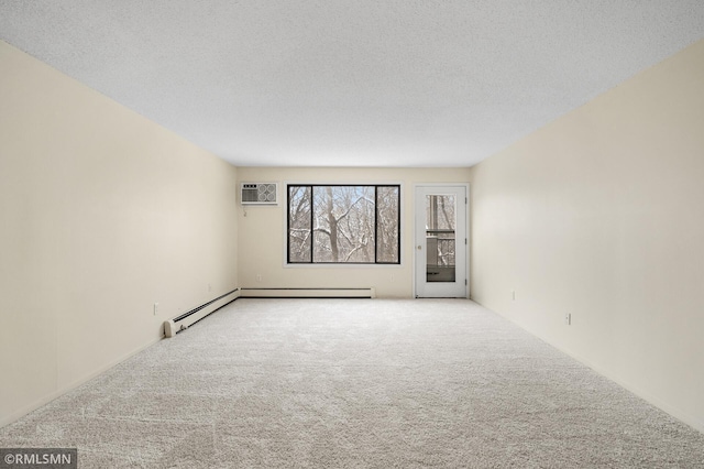 spare room with baseboard heating, light colored carpet, a wall mounted air conditioner, and a textured ceiling