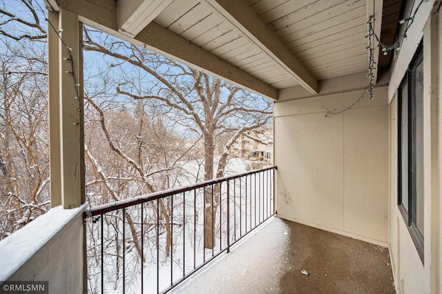 view of snow covered back of property