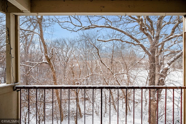 view of snow covered back of property