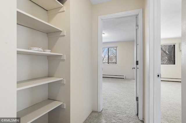 hall featuring a baseboard radiator and light carpet