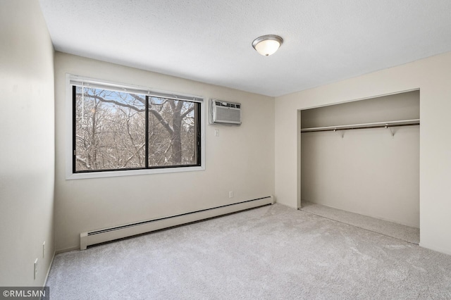 unfurnished bedroom with a wall mounted air conditioner, baseboard heating, light carpet, a textured ceiling, and a closet