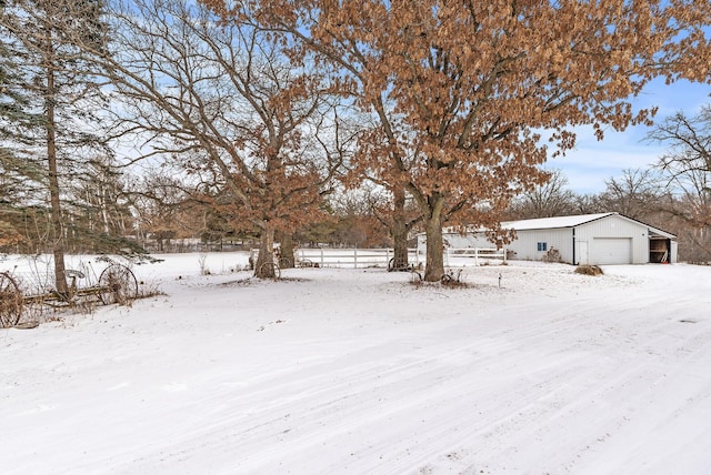 snowy yard with a garage