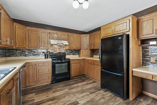 kitchen featuring tasteful backsplash, dark hardwood / wood-style floors, a textured ceiling, and black appliances