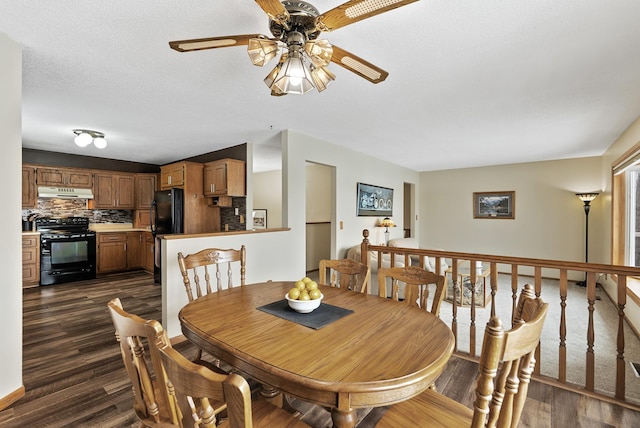 dining area featuring ceiling fan, dark wood-type flooring, and a textured ceiling