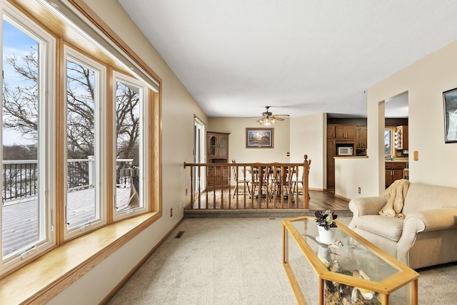 living room featuring ceiling fan and light colored carpet