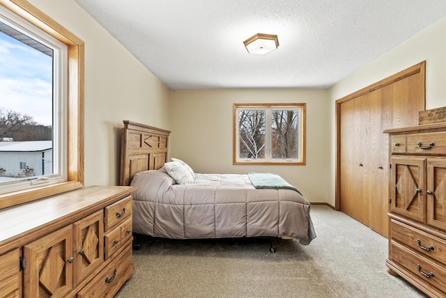 carpeted bedroom featuring a closet and a textured ceiling