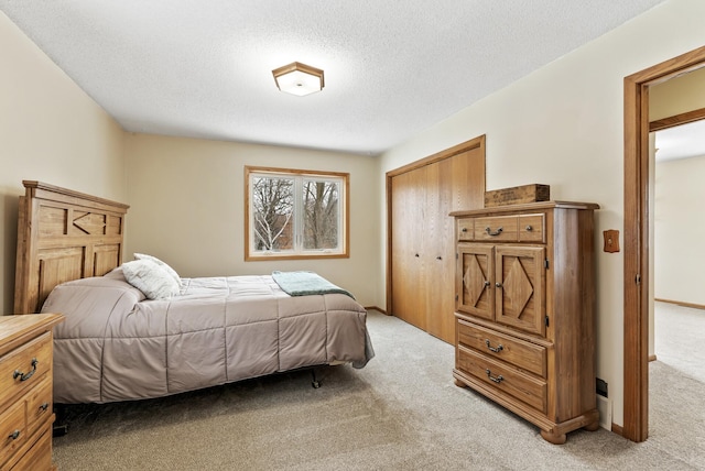 carpeted bedroom featuring a closet and a textured ceiling