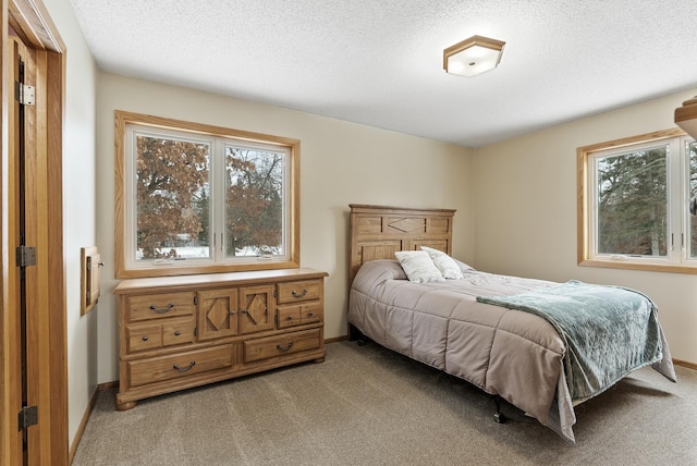 bedroom featuring light colored carpet and a textured ceiling