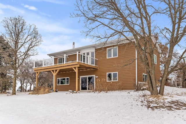 snow covered property with a wooden deck