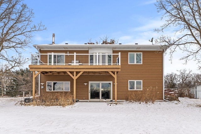 snow covered rear of property featuring a wooden deck