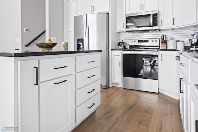 kitchen featuring white cabinetry, dark hardwood / wood-style flooring, tasteful backsplash, and appliances with stainless steel finishes