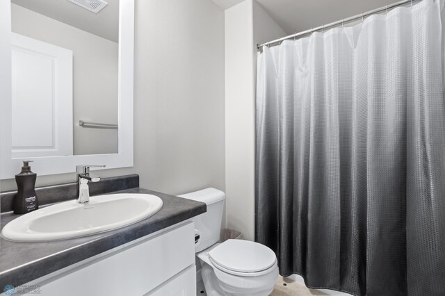 bathroom featuring vanity, toilet, and a shower with shower curtain