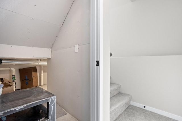 stairway with vaulted ceiling and carpet flooring