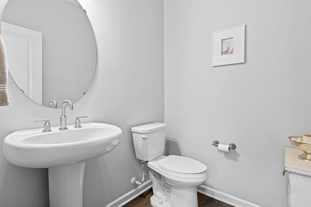 bathroom with sink, toilet, and hardwood / wood-style flooring