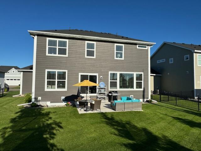 rear view of house with a lawn, a patio, and an outdoor hangout area