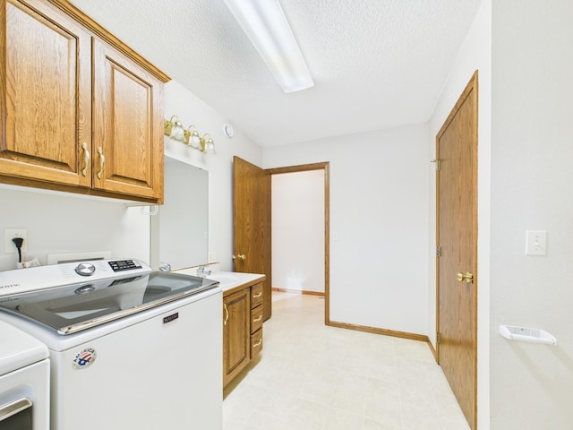 washroom featuring light floors, washer and dryer, cabinet space, a textured ceiling, and a sink