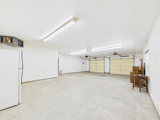 garage with a garage door opener and freestanding refrigerator