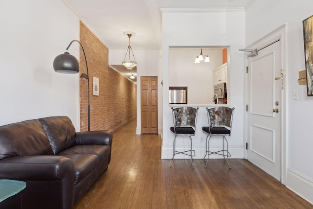 598 Summit Ave Unit 1, Saint Paul, MN 55102 - living room featuring hardwood / wood-style floors, crown molding, brick wall, a chandelier, and baseboards
