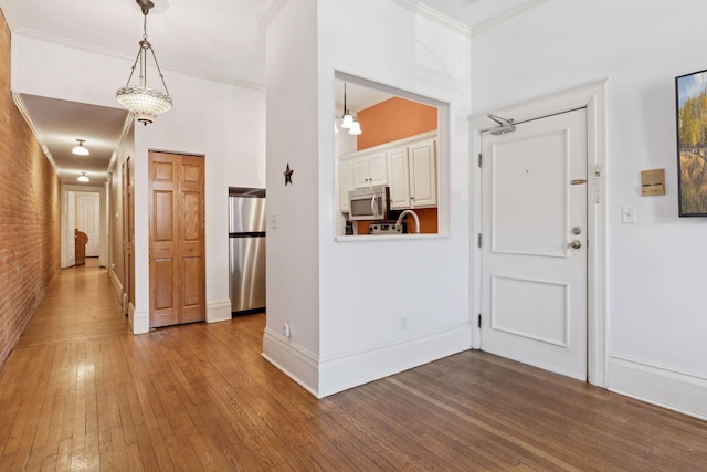 598 Summit Ave Unit 1, Saint Paul, MN 55102 - entryway with hardwood / wood-style floors, crown molding, brick wall, and baseboards
