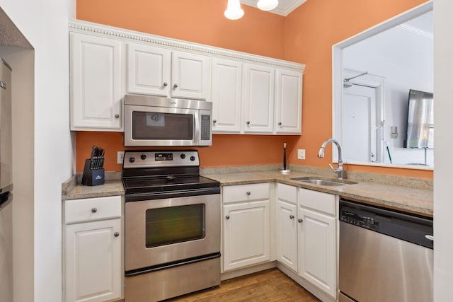 598 Summit Ave Unit 1, Saint Paul, MN 55102 - kitchen with stainless steel appliances, a sink, white cabinets, and light countertops