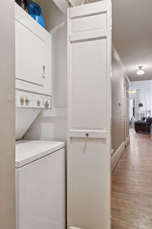598 Summit Ave Unit 1, Saint Paul, MN 55102 - washroom featuring stacked washer / drying machine, wood finished floors, ornamental molding, and a textured ceiling