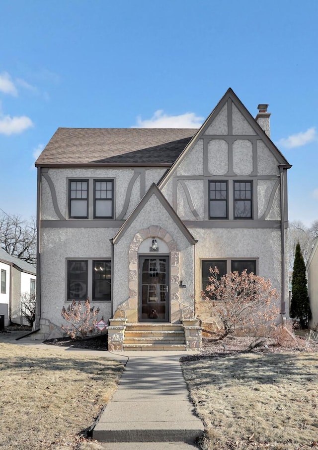 english style home featuring a front yard