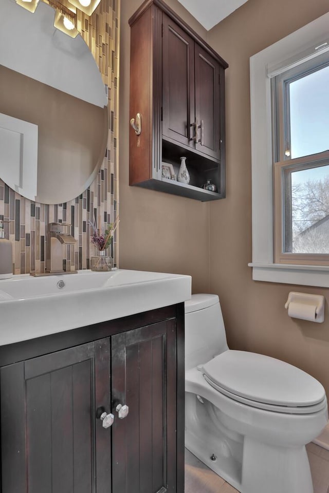 bathroom with vanity, backsplash, and toilet