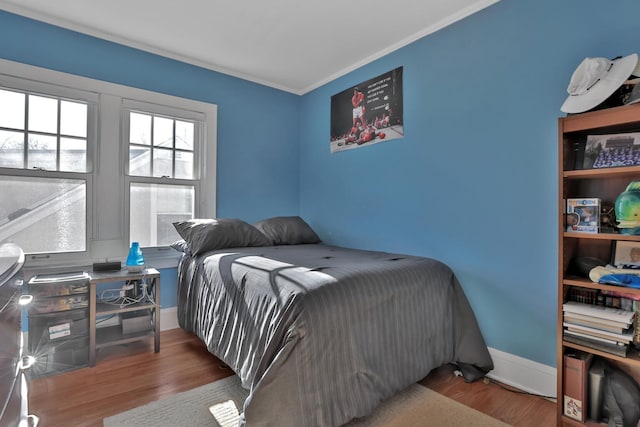 bedroom with crown molding and wood-type flooring