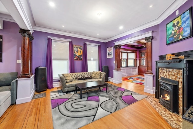 living room with light wood finished floors, decorative columns, and crown molding