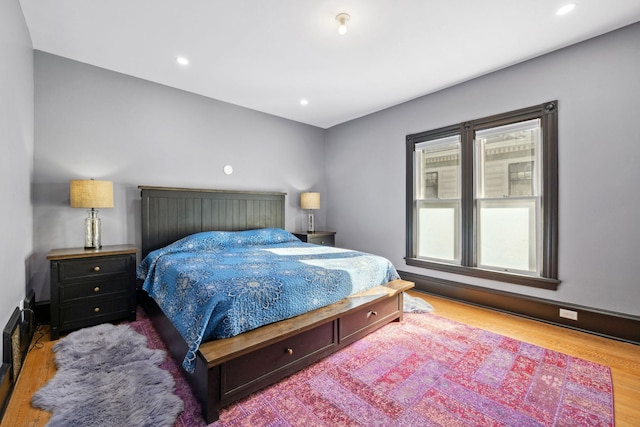 bedroom featuring baseboards, wood finished floors, and recessed lighting