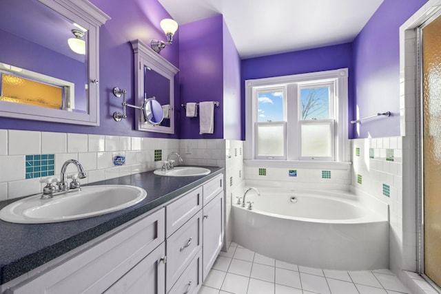 bathroom featuring tile patterned flooring, a garden tub, a sink, and tile walls