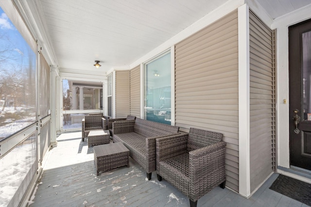 snow covered back of property with outdoor lounge area