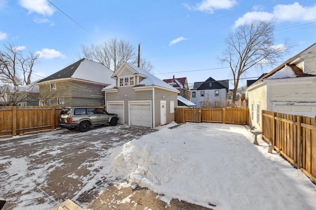 exterior space featuring a garage, a residential view, and fence