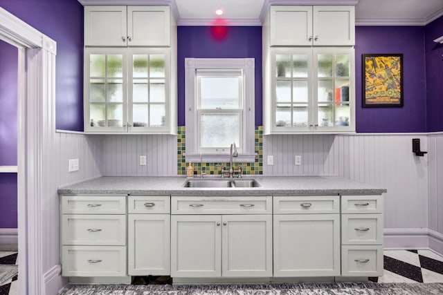 kitchen featuring light countertops, a sink, and white cabinetry